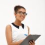 Portrait of young successful african business lady  smiling, writing to folder over white background. Copy space.
